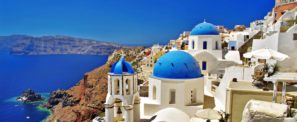 Whitewashed buildings and blue domes above the caldera in Santorini, Greece